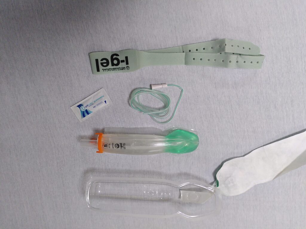 Contingut del I-gel resus pack, de dalt a baix: cinta elàstica perforada per a fixar el dispositiu un cop insertat, sobre unidosi de lubricant, sonda d'aspiració gàstrica, dispositiu supraglòtic I-gel, talla 5, amb banda de suport per la fixació a l'extrem distal de color taronja, que és el que correspon a la mida del dispositiu. Finalment l'envàs transparent que també és útil per a distribuir de forma uniforme el lubricant