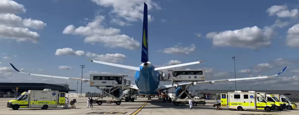 Vista posterior de l'avió, aparcat a l'aeroport, amb diverses ambulàncies al voltant